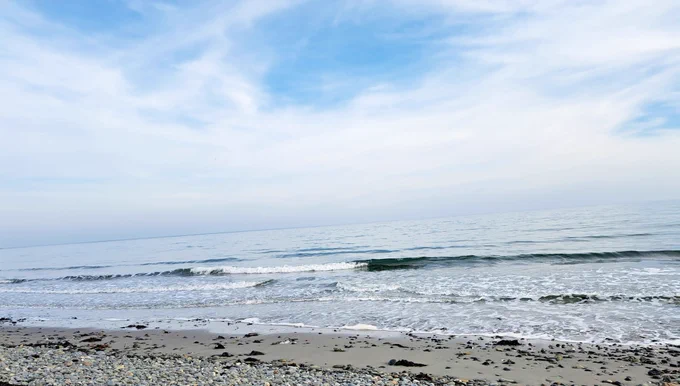 Photo of Cloughey Beach with the waves rolling onto the sandy beach