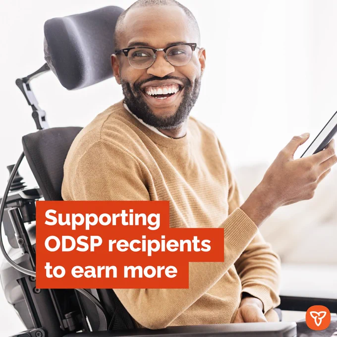 Man in wheelchair holding a cell phone. 