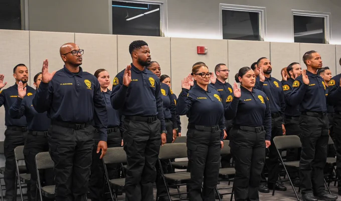 Officers raising their right hands as they take their oath during a swearing-in ceremony.