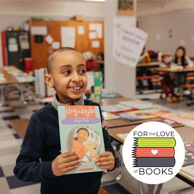 Student at Vernon Elementary in Portland holding a book they are reading with our SMART volunteer.