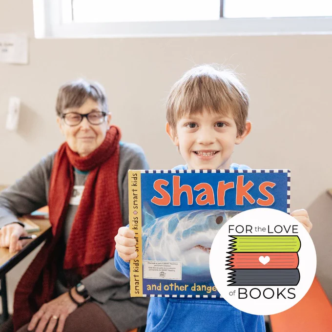 Student at Vernon Elementary in Portland holding a book they are reading with our SMART volunteer.