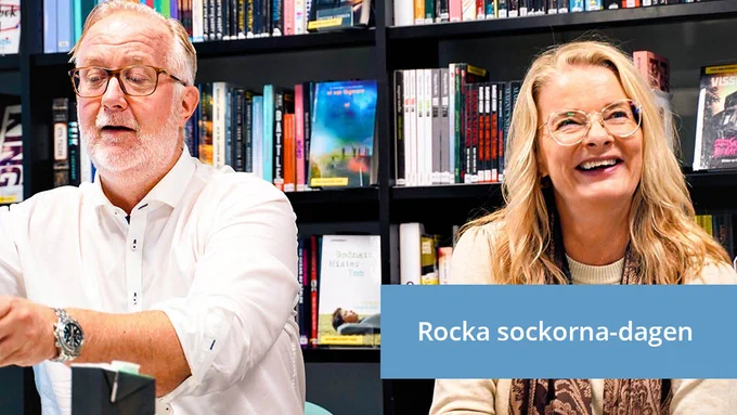 Johan Pehrson och Lotta Edholm sitter i ett bibliotek. I bilden står "Rocka sockorna-dagen".