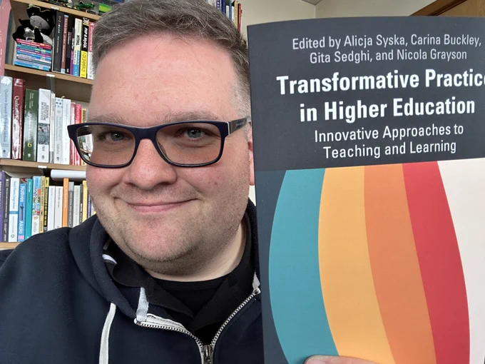 Dr Lee Fallin holds a copy of Transformative Practice in Higher Education