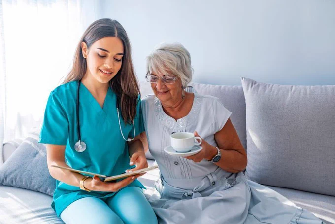 Photo of doctor sat on sofa with patient looking at chart together