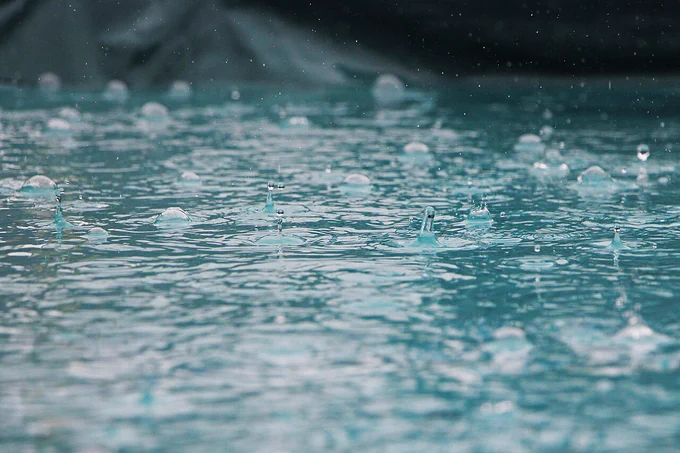 Raindrops falling into shallow water