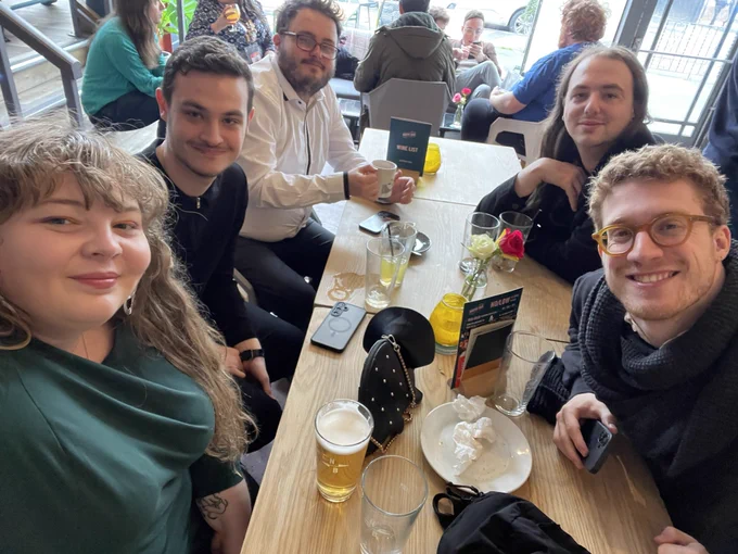 Katharine and a group of people at a table with beers