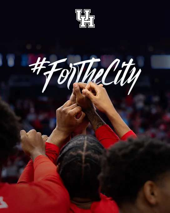 Close-up of hands held up in a huddle with hashtag For The City floating just above them.