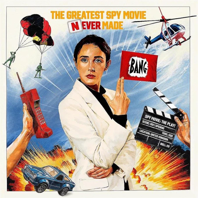 Spoof Bond-style poster. Female secret agent stands centre with her fingers posed in the shape of a gun. A comedy flag comes out of them saying BANG. Behind her is an explosion, a toy car speeds away from the blast. Above, a helicopter flies hanging from a threas and two toy parachutists descend. To the left a  hand offers a 70s/80s style chordless phone. To the right another hand holds a film clapperboard which has "Spy Movie: The Play!" written on it.