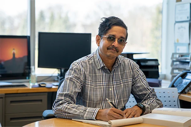 Vijaykirshnan Narayanan sits at desk and poses for photo