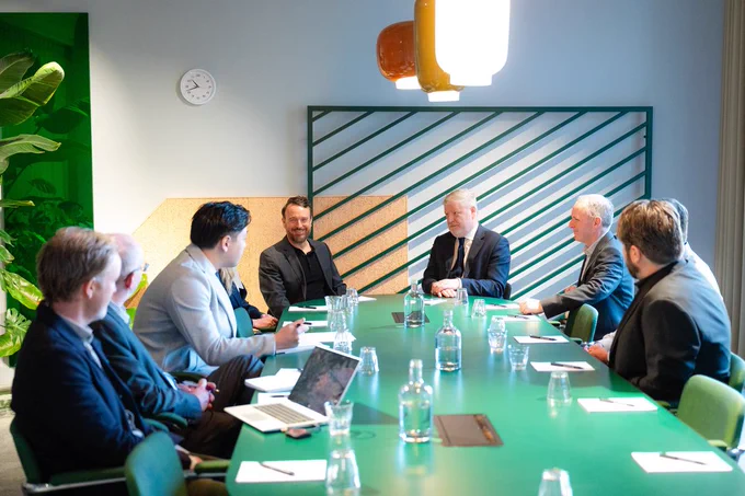 Image of  people sitting round a table having a meeting.