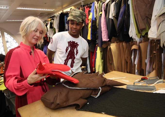 Justine Simons with designer YAKU looking at their designs. 