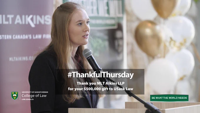 Female law student speaking at a microphone at announcement.