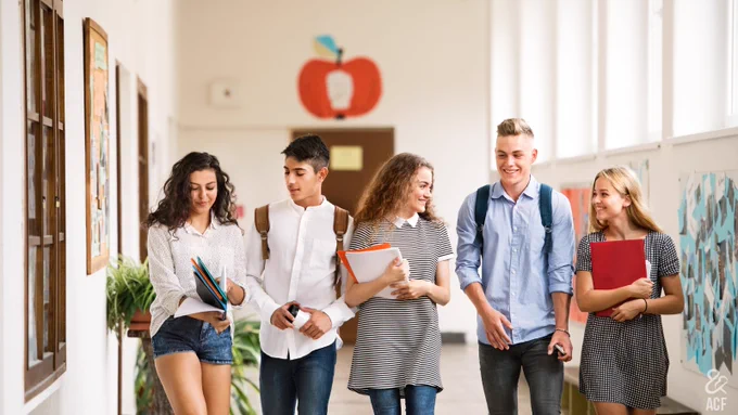 Group of high school teens walking down the hallway.