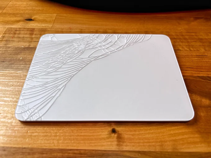 Untitled (Despair, 2025)
Glass, aluminum, existential dread
Artist: Peter Doyle
Shattered apple trackpad on lefthand side. Cracked glass in abstract design. Accidentally created during a moment of digital frustration. This piece explores the fragility of modern interfaces and the consequences of gravity. Critics call it “Apple meets angst.”
On loan from the Collection of Things That Used To Work.