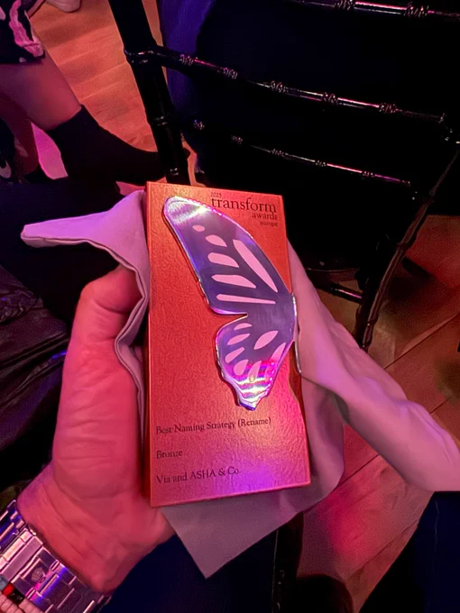 close up of bronze transform award adorned with half an iridescent butterfly wing