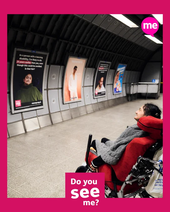 Mencap campaigners posing next to posters in the Westminster tube station.  The text says "People with a learning disability die, on average, up to 20 years younger than the general population, even though this could be avoided with the right healthcare."