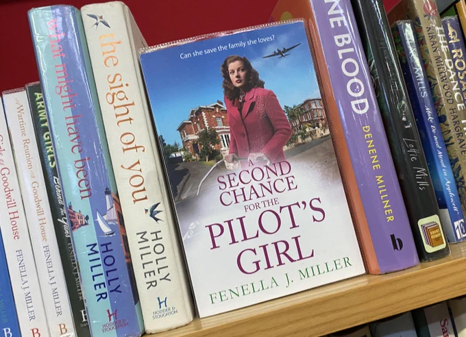 A book titled "Second Chance for the Pilot's Girl" by Fenella J. Miller on display among other books on a shelf.