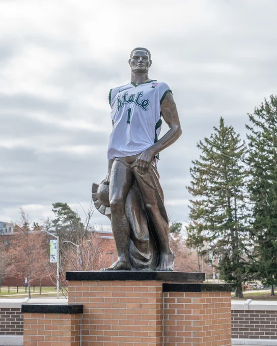 The Spartan statue wearing a white basketball jersey with the number 1 that in green says State in the State script