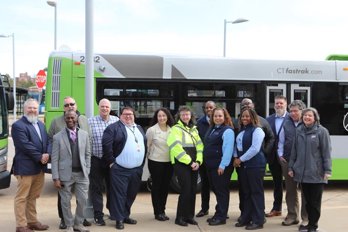 CT Transit staff pose in front of a CTfastrak bus