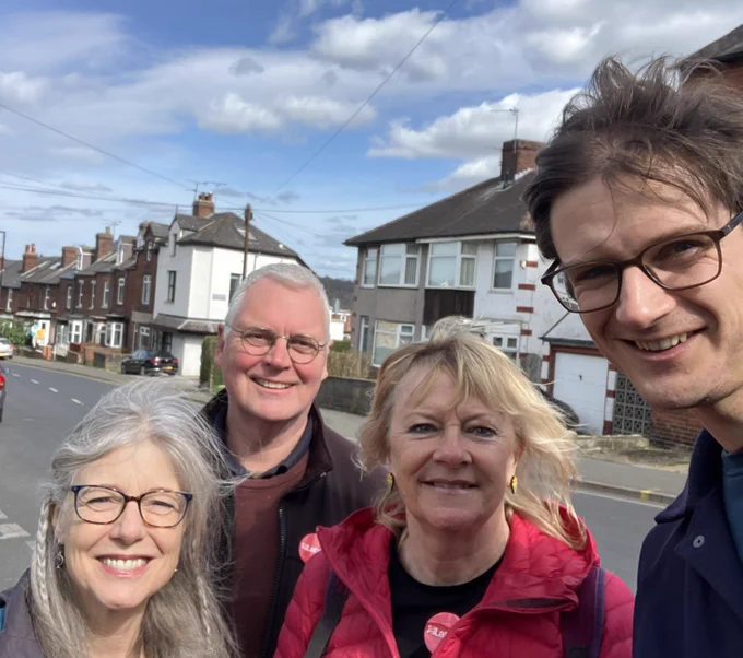 A photo of Cllr Tom Hunt and three Labour campaigners. They are standing by a road in front of some houses