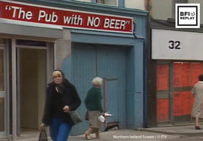 Two women walking past a storefront named "The Pub with NO BEER". Image courtesy of Northern Ireland Screen copyright ITV. Logo: BFI Replay
