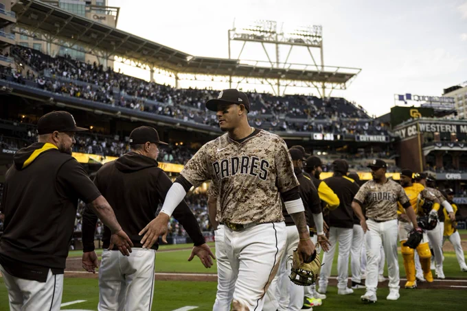 Photo of Manny Machado walking through the Padres high five line after sweeping the Braves. He is wearing the Padres tan camo uniform that is worn each SD Military Sunday.