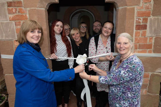 A posed shot of the ribbon cutting for the home