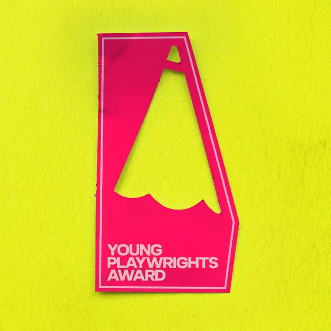 A pink shape on a yellow background says: Young Playwrights Award. The pink shape has two holes that are styled as the tip of a pencil.