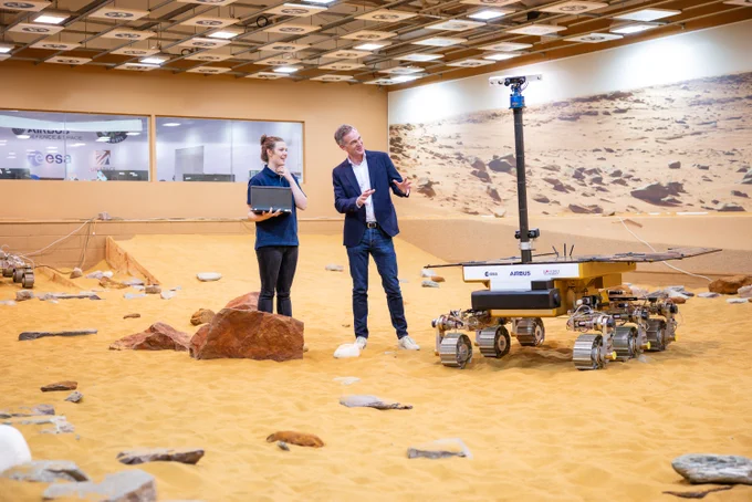 Senior GNC and Robotics Engineer Yvonne Pickering (left) speaks to Technology Secretary Peter Kyle (right) about the Mars Rover robot as they stand on the Mars Yard simulation environment. 