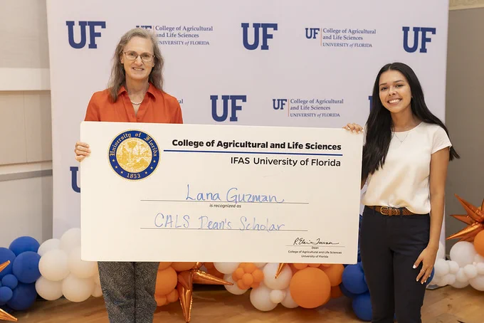 Lana Guzman and Elaine Turner pose for a photo holding a scholarships certificate.