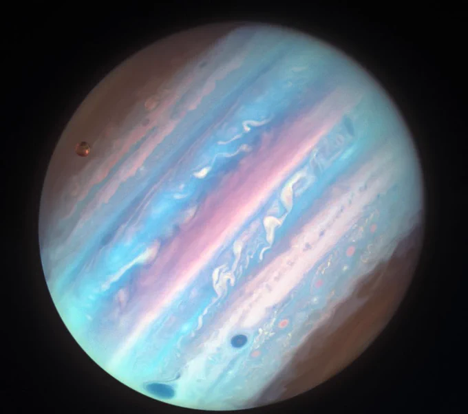 Hubble's ultraviolet view of Jupiter shows the planet in hues of pink and blue.