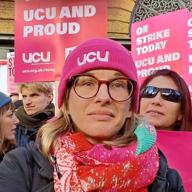 A photograph of Agnes Flues in a UCU hat in front of other UCU members at a rally.