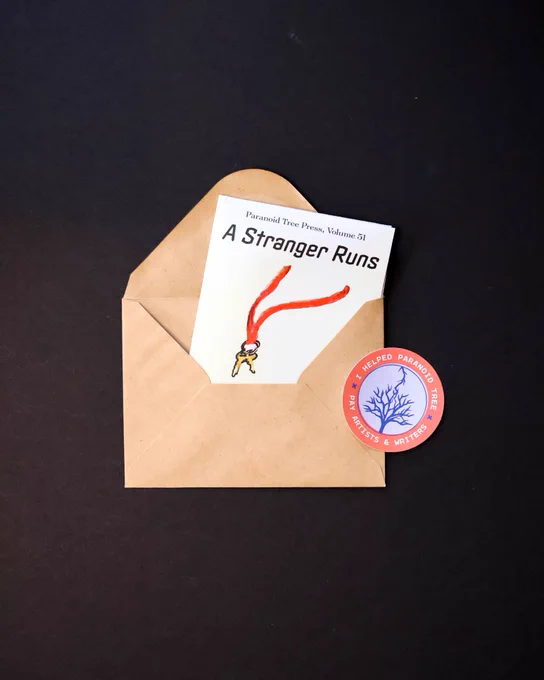 Volume 51 folded up and tucked into an envelope, alongside a Paranoid Tree sticker. This is how the issue arrives in the mail to print subscribers.