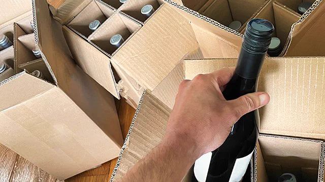 Kuvituskuvassa useita pahvilaatikoita, jotka sisältävät viinipulloja.