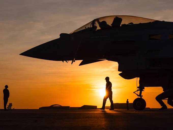 The front of a Typhoon with the sunset behind it, from the side.