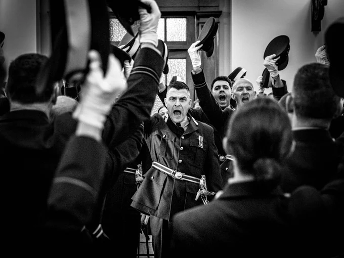 RAF Personnel holding caps in the air in 'cheers'.