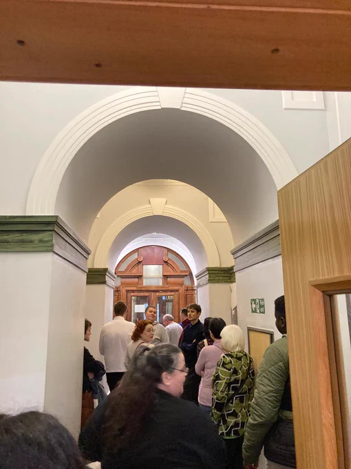 GDA members follow the Mitchell Library tour guide through an archway. 