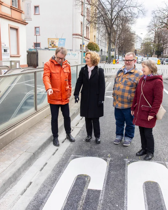Wolfgang Siefert (Mobilitätsdezernent), Michaela Kraft (Leiterin des Amtes für Straßenbau und Erschließung), Michael Wejwoda (Leiter der Abteilung „Planen und Bauen“ im Amt für Straßenbau und Erschließung) und Barbara Zeibekis (Stadtentwässerung Frankfurt) neben der neu eingebauten Betonschlitzrinne auf der Mörfelder Landstraße, © Stadt Frankfurt am Main, Foto: Martin Leissl