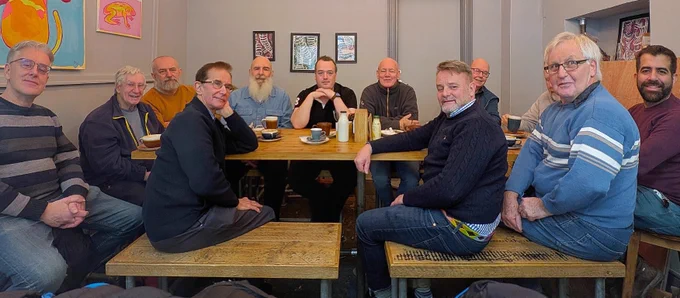 people around a table smiling and looking at camera