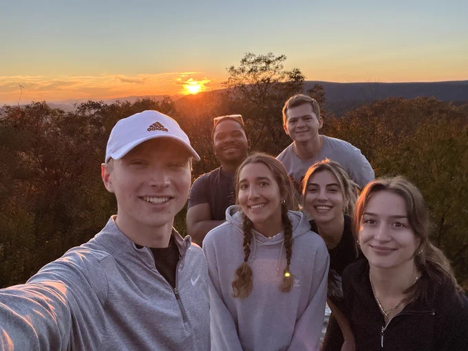 Photo of students taking a photo during sunset. 