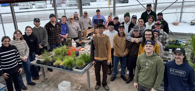Students gathered in the greenhouse