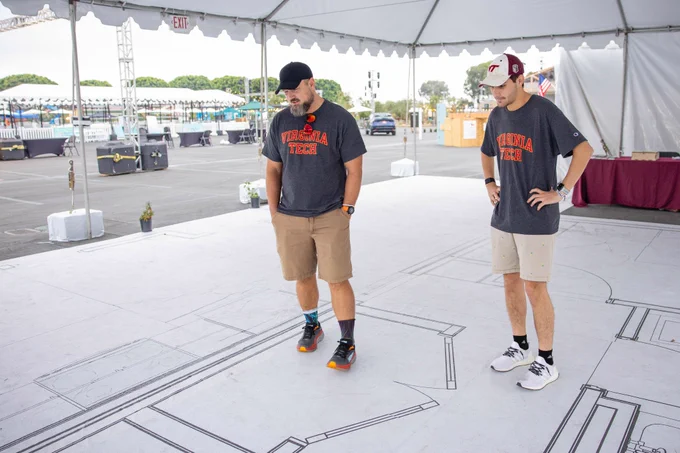 Photo of members of the team standing on a full-scale outline. 