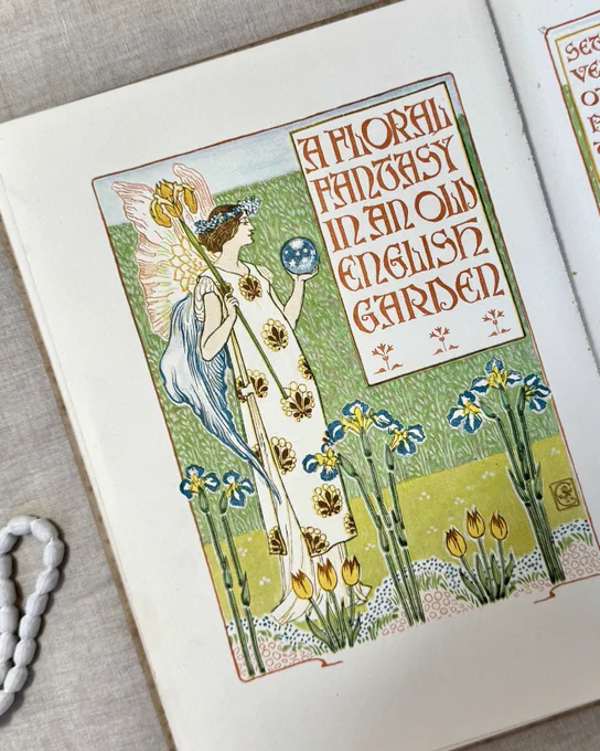 A stylised illustration of a woman, or fairy, holding a crystal ball. There are stylised irises and tulips. 