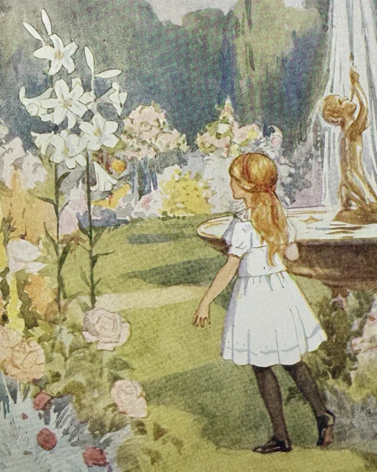 A young girl in a white dress in a garden full of colourful flowers. 