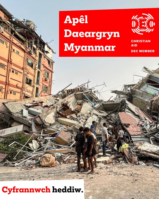 Image: People stand past the debris of a collapsed building in Mandalay, Myanmar, on 28 March 2025 after the earthquake. Overlaid is the text "Myanmar Earthquake Appeal" with the DEC logo next to it. At the bottom the text reads "Donate today".