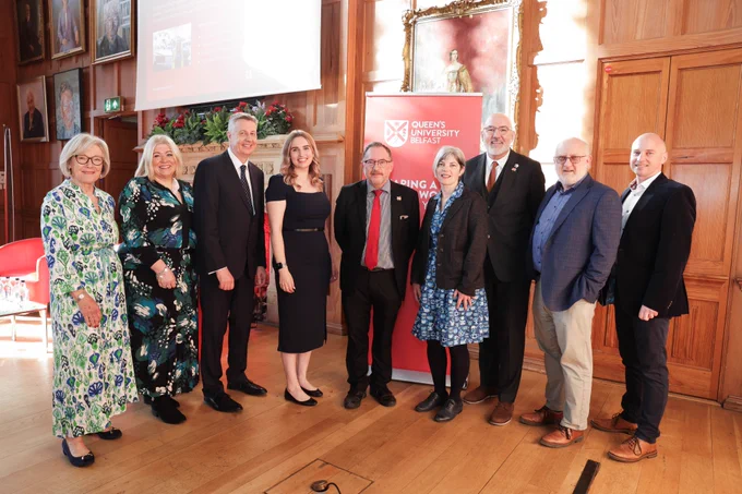 Image shows a group of Queens staff, KTP associates and partners standing on the stage in the Great Hall.