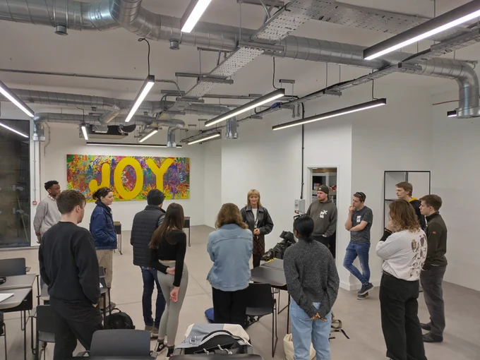 Creative Futures Get Into Event Production course. Young people people stood in a huddle facing their teacher.