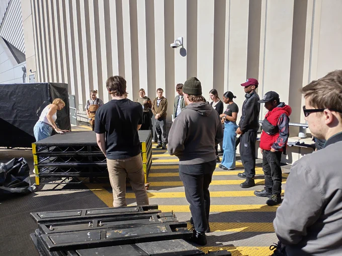 Creative Futures Get Into Event Production course. Young people people outside learning how to put a stage together. 