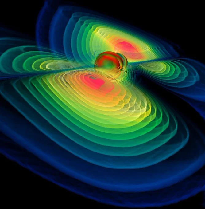 Computer-generated simulation of the gravitational waves radiating outwards from two merging black holes. Colours indicate the intensity of the waves from strongest to weakest, red, then yellow, green and blue. 
Image credit: Werner Benger, Albert Einstein Institute, Max Planck Institute of Gravitational Physics, Potsdam, Germany. Reproduced under CC BY 4.0.