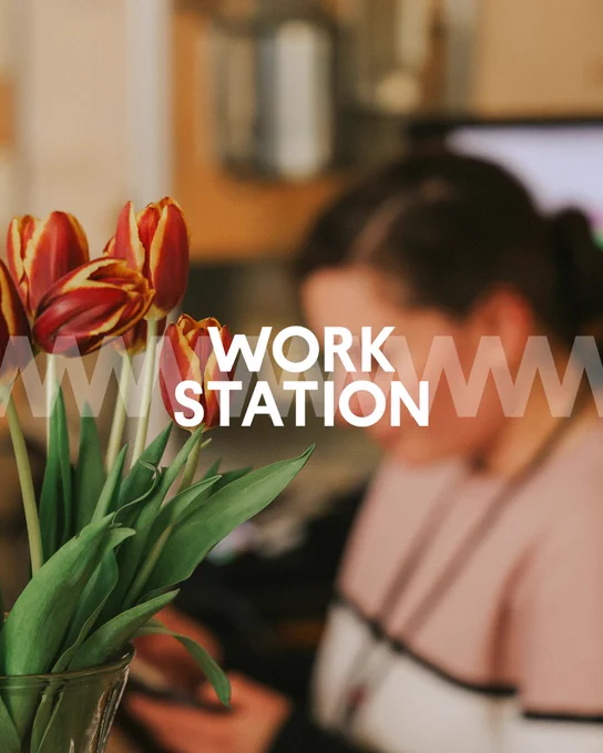 Blurred background of a person at a workstation with a clear foreground of vibrant tulips and text overlay reading 'WORK STATION'.